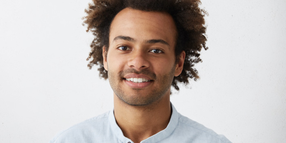 Headshot Good Looking Positive Young Dark Skinned Male With Stubble And Trendy Haircut Wearing Blue Shirt